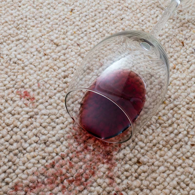 Umgestürztes Weinglas auf Teppicboden